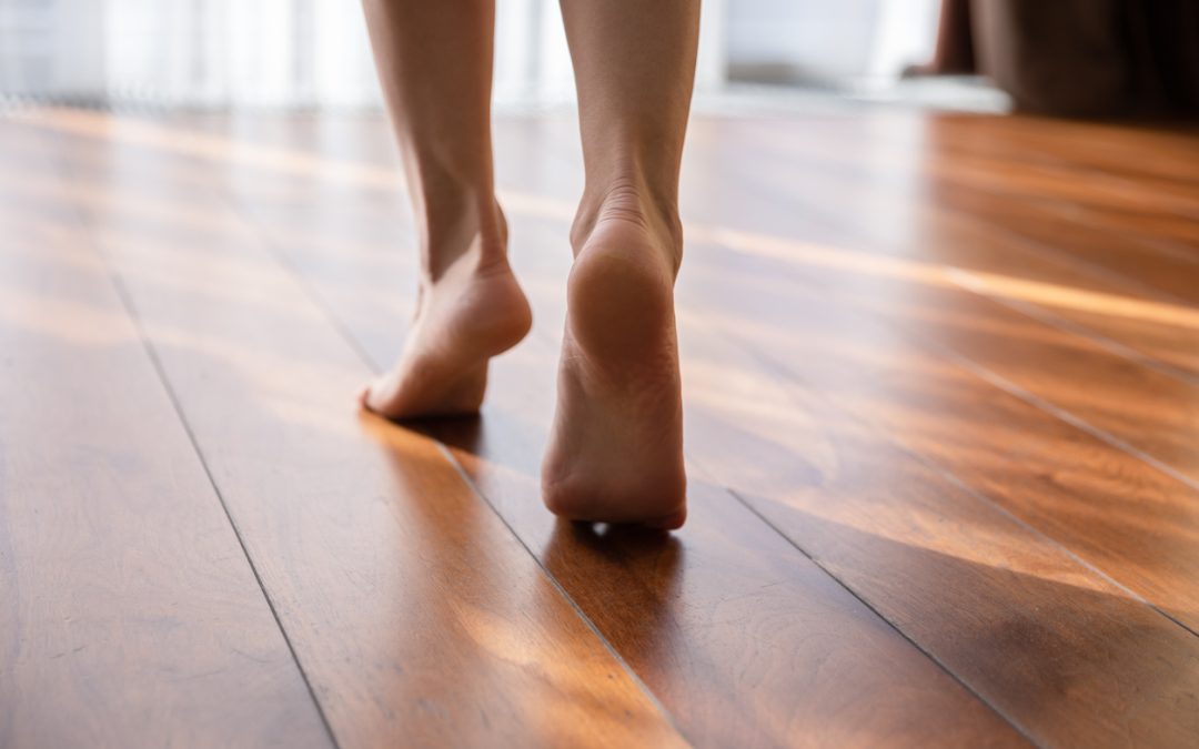 woman walking barefoot on wooden floorboards