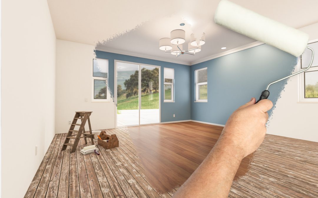 Man painting roller with fresh blue paint to reveal a newly remodeled room completing his DIY home improvement projects.
